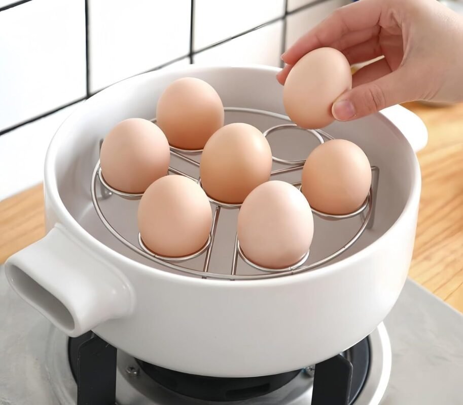 Support à œufs avec sept œufs dans une casserole blanche sur une plaque de cuisson