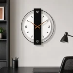 Horloge murale minimaliste avec barre verticale noire sur un mur de bureau gris au-dessus d’un bureau