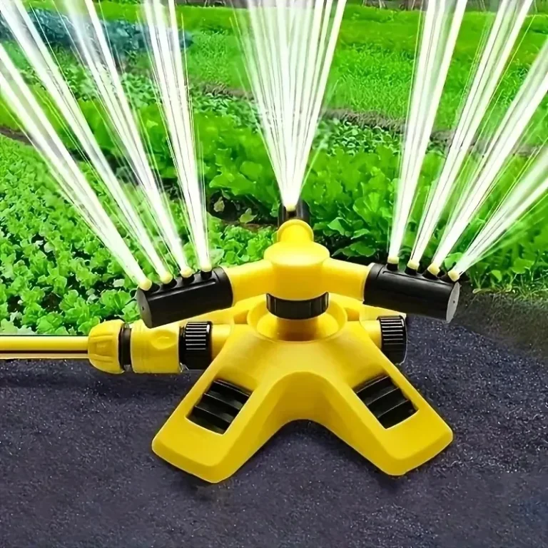 Arroseur de jardin rotatif jaune arrosant un potager