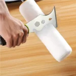 Main utilisant le grattoir multi-outil en acier inoxydable pour nettoyer un rouleau à peinture sur une table en bois