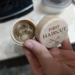 Boîte en bois ouverte pour première mèche de cheveux contenant une mèche de bébé