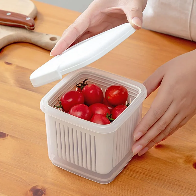 Mains ouvrant la boîte de conservation avec panier égouttoir rempli de tomates cerises sur une table en bois