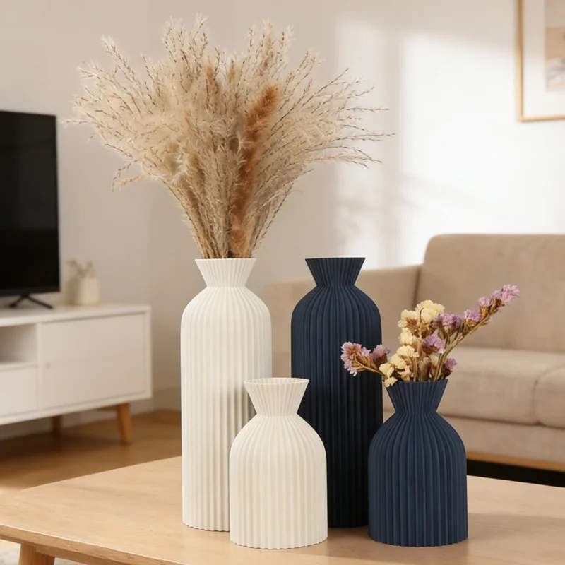 Vases striés de deux hauteurs avec fleurs séchées sur une table basse de salon